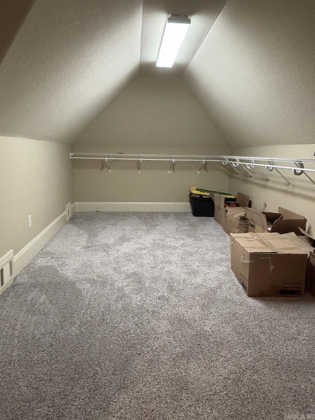 spacious closet featuring vaulted ceiling and carpet floors