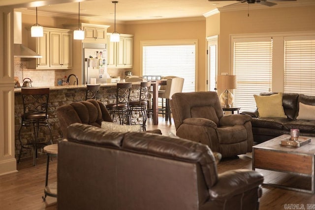 living room with ornamental molding, light hardwood / wood-style floors, and ceiling fan