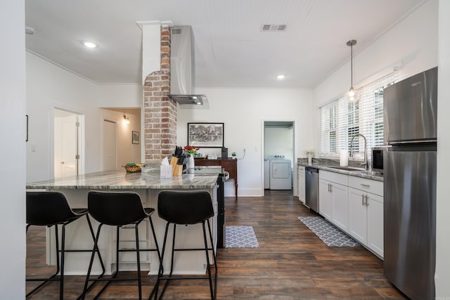 kitchen featuring appliances with stainless steel finishes, sink, white cabinetry, pendant lighting, and dark hardwood / wood-style floors