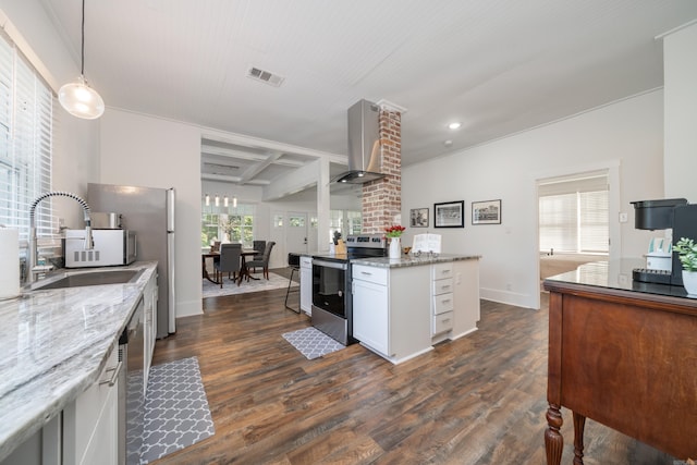 kitchen with wall chimney range hood, white cabinets, hanging light fixtures, light stone counters, and stainless steel appliances