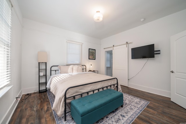 bedroom featuring dark wood-type flooring and a barn door