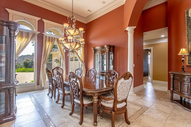 dining area featuring a towering ceiling, a notable chandelier, ornamental molding, and ornate columns