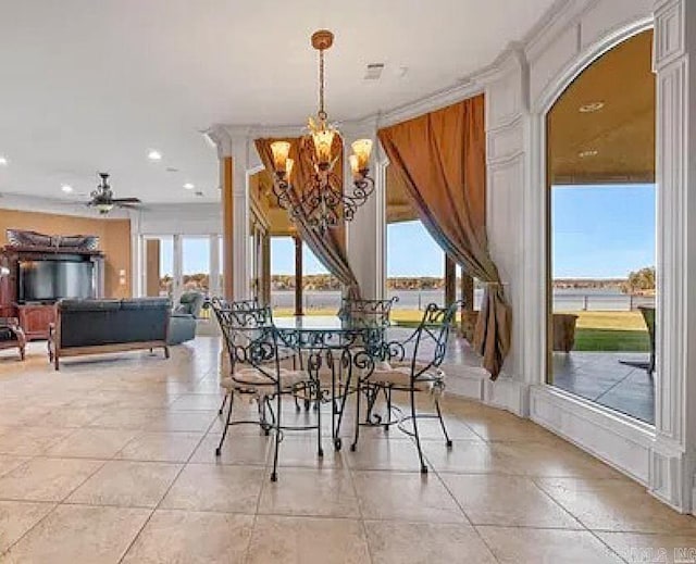 dining area with a water view, light tile patterned flooring, ceiling fan with notable chandelier, and plenty of natural light