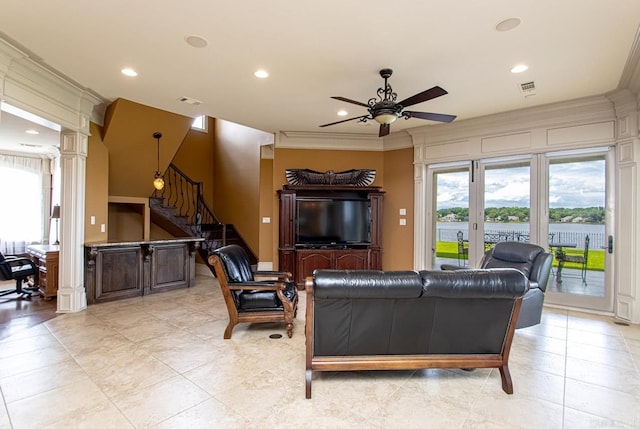 living room with ornate columns, crown molding, and ceiling fan