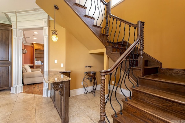 stairway with ornamental molding and tile patterned floors