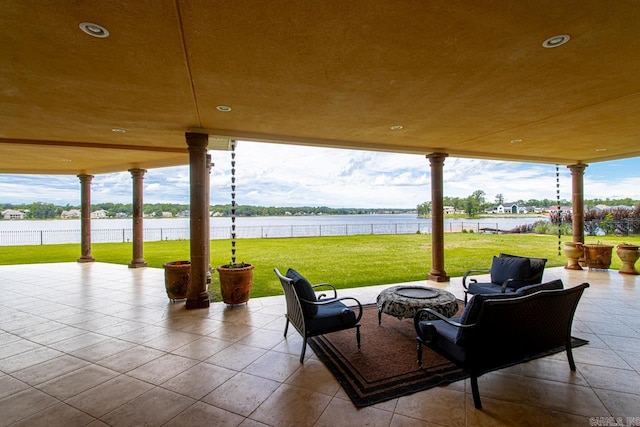 view of patio with a fire pit and a water view