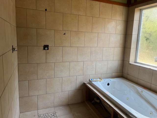 bathroom featuring a healthy amount of sunlight, tile patterned floors, and a tub to relax in