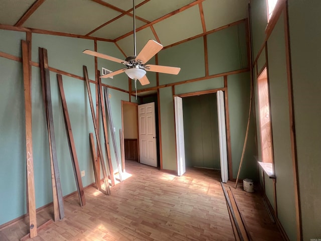 spare room featuring light hardwood / wood-style floors, high vaulted ceiling, and ceiling fan