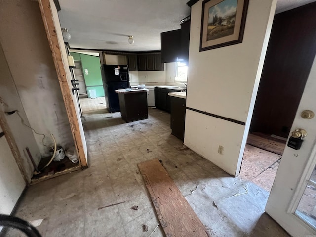 kitchen with a center island, sink, and black fridge