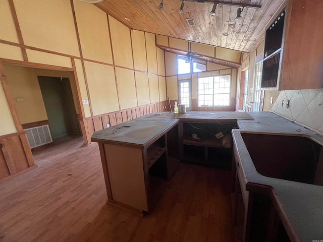 kitchen with kitchen peninsula, dark hardwood / wood-style floors, and wooden ceiling