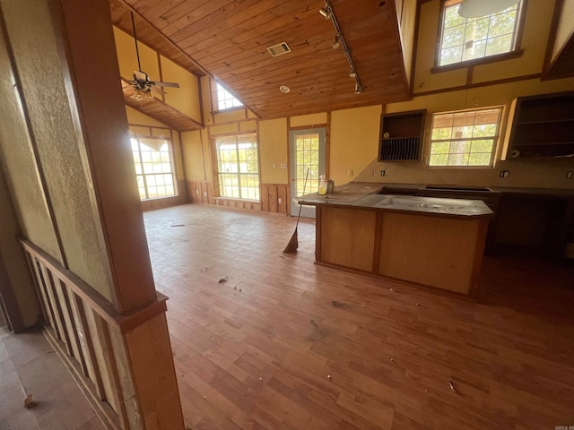 kitchen featuring wood ceiling, ceiling fan, rail lighting, high vaulted ceiling, and light hardwood / wood-style flooring