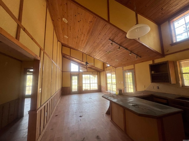 kitchen featuring kitchen peninsula, rail lighting, high vaulted ceiling, wooden ceiling, and light hardwood / wood-style flooring