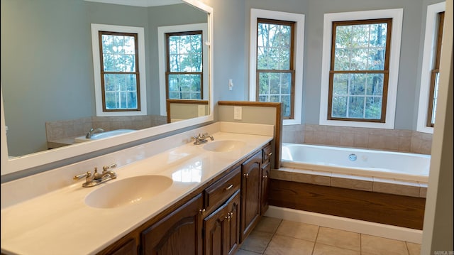 bathroom with vanity, a relaxing tiled tub, and tile patterned floors