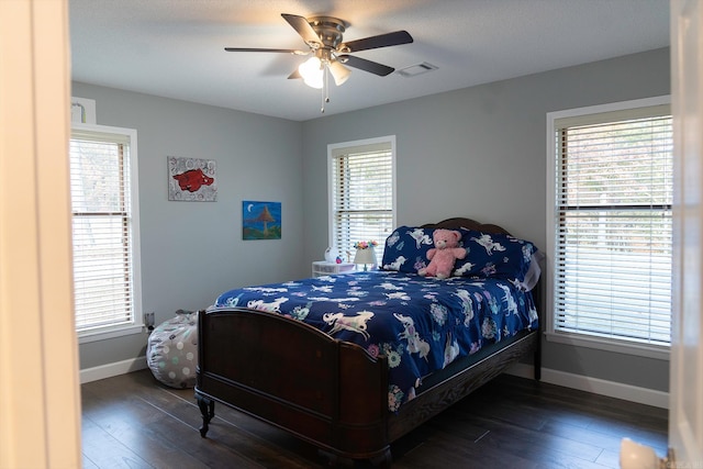 bedroom with dark hardwood / wood-style flooring, multiple windows, and ceiling fan