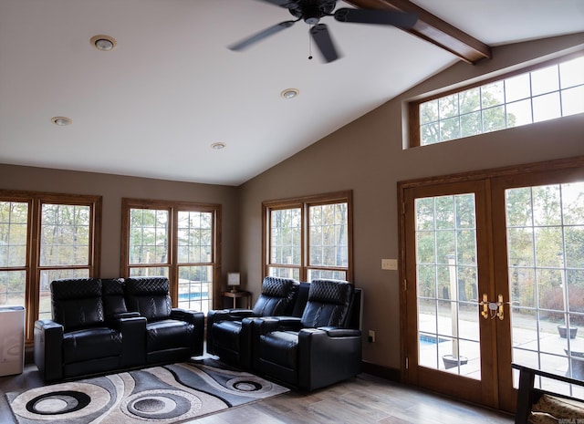 living room with a wealth of natural light, french doors, lofted ceiling with beams, and light hardwood / wood-style floors