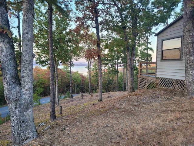 yard at dusk featuring a wooden deck