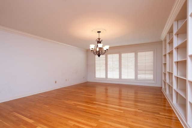 unfurnished room with light hardwood / wood-style floors, an inviting chandelier, and crown molding