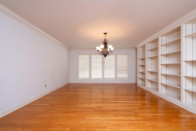 spare room featuring light hardwood / wood-style floors, ornamental molding, and a chandelier