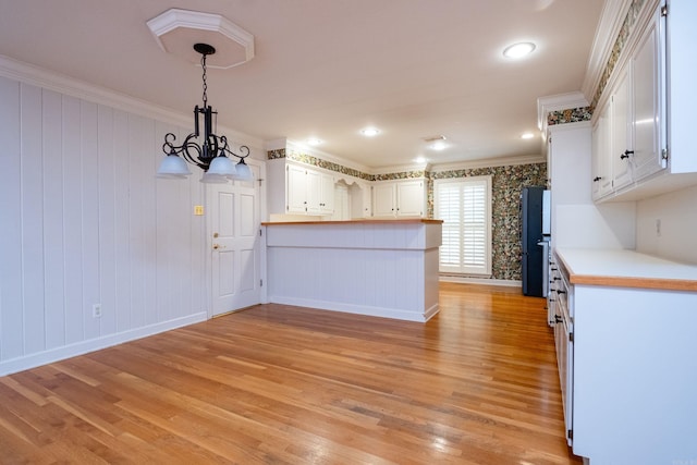 kitchen with light hardwood / wood-style floors, ornamental molding, and white cabinets