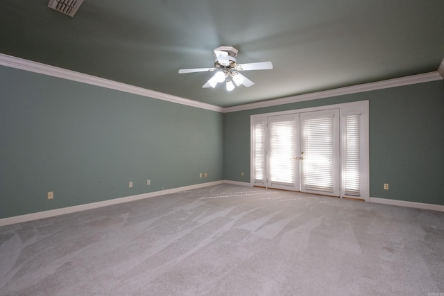 spare room featuring crown molding, light colored carpet, french doors, and ceiling fan