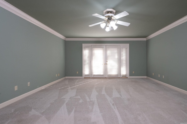 spare room featuring crown molding, french doors, light colored carpet, and ceiling fan