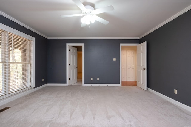 unfurnished bedroom featuring ornamental molding, light carpet, and ceiling fan