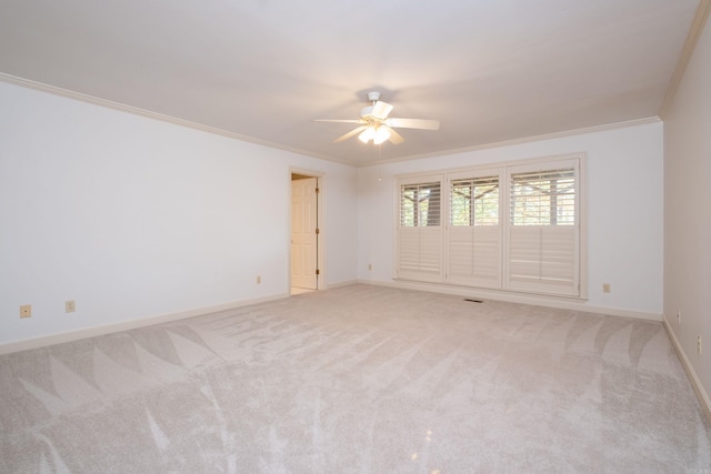 spare room featuring crown molding, light carpet, and ceiling fan