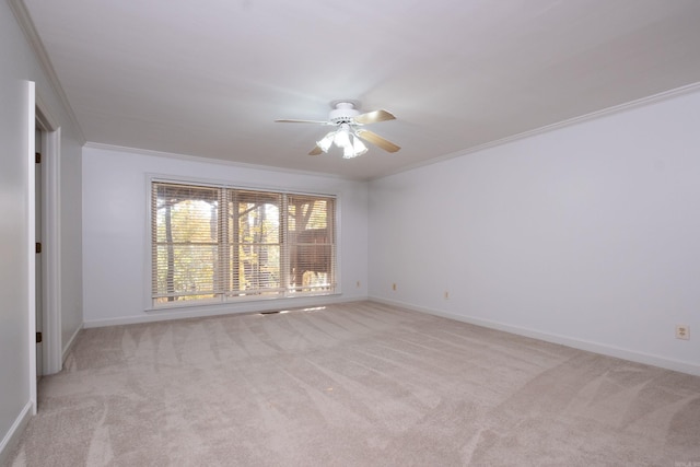 carpeted spare room featuring crown molding and ceiling fan