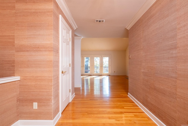 hall featuring french doors, ornamental molding, and light hardwood / wood-style flooring