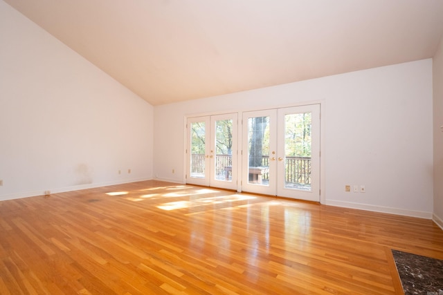 spare room with french doors, high vaulted ceiling, and light wood-type flooring