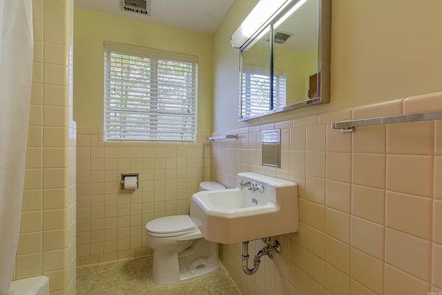 bathroom with sink, a shower with shower curtain, toilet, tile walls, and tile patterned flooring