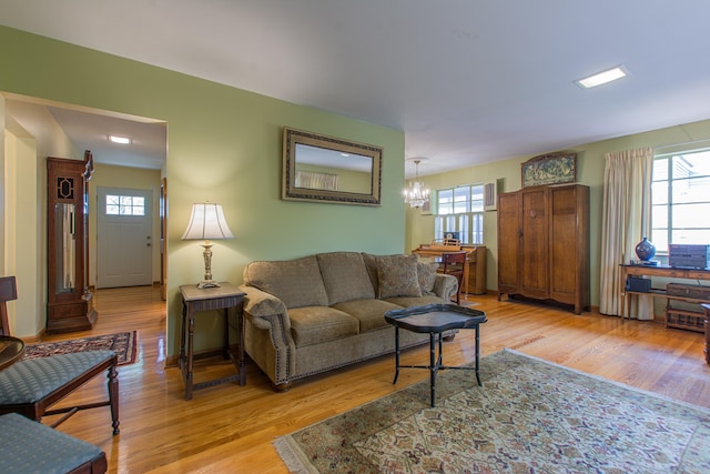 living room featuring light hardwood / wood-style floors, a notable chandelier, and plenty of natural light