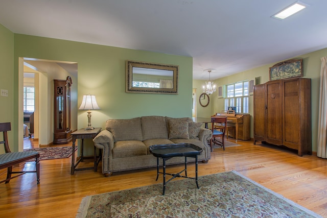 living room featuring a notable chandelier and light wood-type flooring