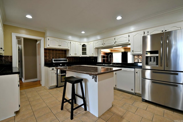 kitchen with white cabinets, white dishwasher, sink, stainless steel refrigerator with ice dispenser, and a center island