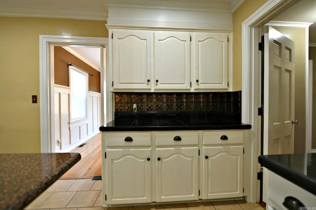 kitchen with decorative backsplash, white cabinets, and light tile patterned floors