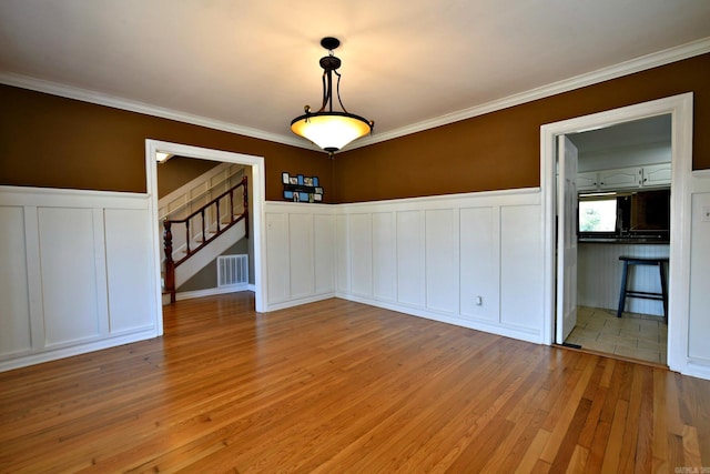 unfurnished room with light hardwood / wood-style floors and crown molding