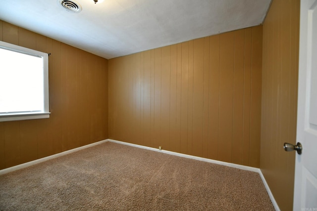 carpeted empty room with wooden walls