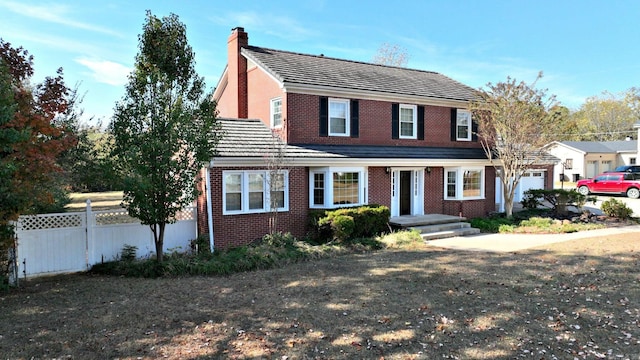 301 Reine St, Mena, AR 71953 - view of front of house featuring brick siding, fence, and a chimney