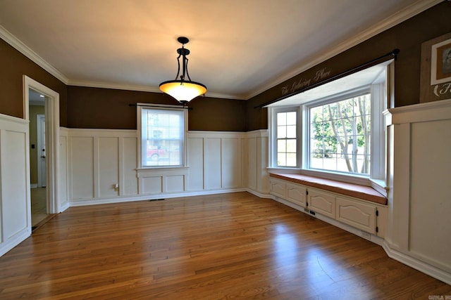 unfurnished dining area featuring ornamental molding, hardwood / wood-style floors, and plenty of natural light