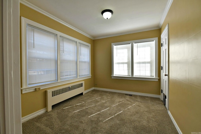 spare room featuring ornamental molding, dark colored carpet, and radiator heating unit