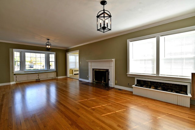 unfurnished living room with ornamental molding and light wood-type flooring