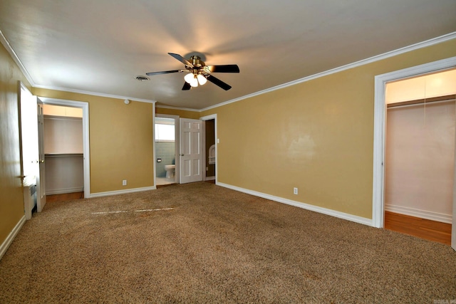 unfurnished bedroom with ceiling fan, ornamental molding, carpet floors, and two closets