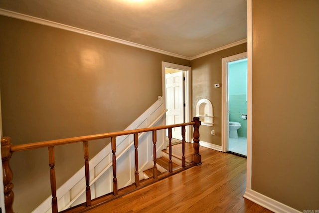 stairway featuring crown molding and wood-type flooring