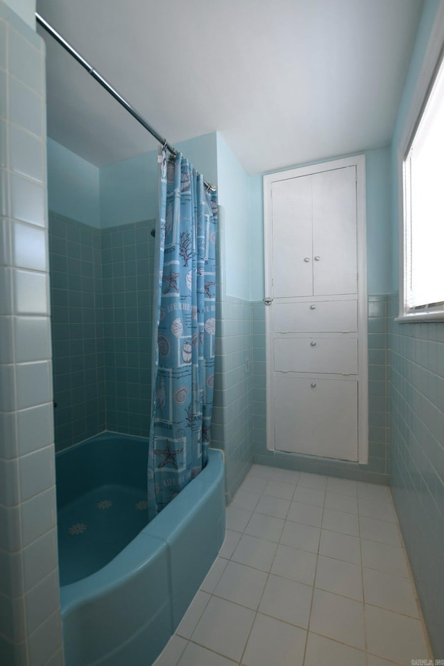 bathroom with tile walls, shower / tub combo with curtain, and tile patterned floors