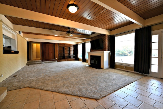 unfurnished living room with wood ceiling, beamed ceiling, light colored carpet, and ceiling fan