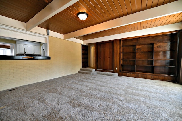 unfurnished living room with beam ceiling, wooden ceiling, and carpet floors