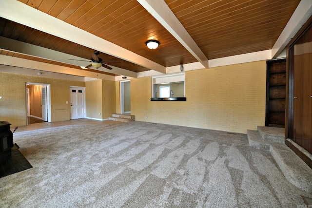 unfurnished living room featuring beam ceiling, carpet floors, and ceiling fan