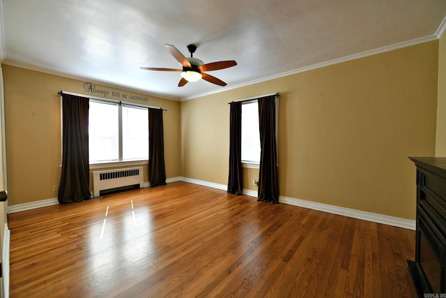 empty room with radiator, ceiling fan, ornamental molding, and hardwood / wood-style floors