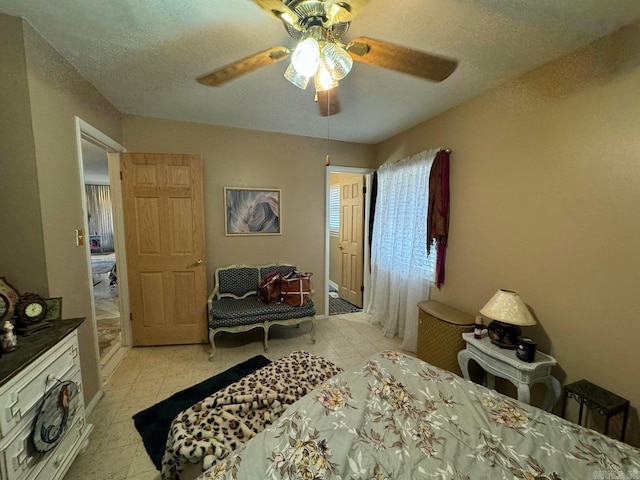 bedroom with ceiling fan, a textured ceiling, and light tile patterned floors