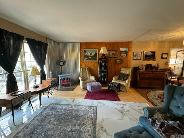 living room with a wood stove and wood walls